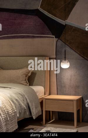 Modern bedroom interior with pendant lamp. Cozy bed in a designer room. Stock Photo