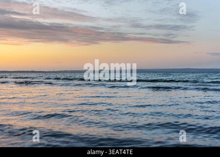 Wide sea panorama at sunset. Clouds over horizon in warm evening colors. Stock Photo