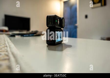 Close-up of a DJI Osmo Nano action camera with its Vision Dock on a white surface in Cagliari, Sardinia. The modular design features a small OLED scre Stock Photo