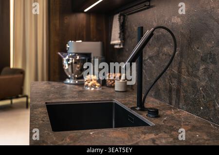 Stylish kitchen area with marble countertop and faucet. Stock Photo
