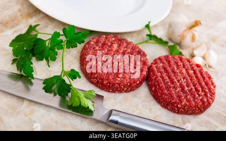 Two raw juicy beef burger cutlets are prepared for frying Stock Photo