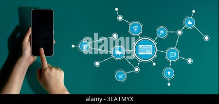 A hand interacts with a smartphone displaying digital marketing icons, symbolizing connectivity, social media interaction, and modern online commerce Stock Photo