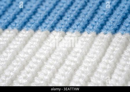 Close-up sweater texture in blue and white colors, knitted striped surface in macro detail. Concept of synthetic textile durability, tactile material Stock Photo