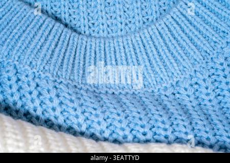 Close-up of pastel blue color sweater neckline with ribbed collar and knitted texture in synthetic material. Macro knitwear detail with soft tactile s Stock Photo