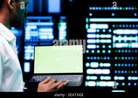 Developer examining server rigs performance trends using chroma key device. Expert using green screen laptop to discover data center damage troubles arising due to high CPU usage Stock Photo