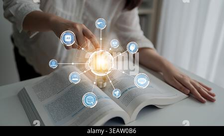 A person engages with a book, highlighting the fusion of traditional learning and modern technology, represented by a glowing light bulb icon Stock Photo