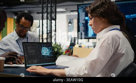 Programmers in office using specialized technology to accelerate complex AI calculations. IT workers managing neural network training datasets with notebook device, camera A Stock Photo