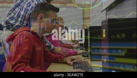 Typing male in red hoodie working at classroom lab, with monitors keyboards towers and stock charts Stock Photo