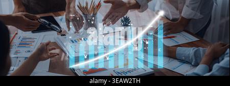 A business team collaborates in a modern workspace, focusing on growth charts and digital analytics, showcasing effective teamwork and strategy Stock Photo