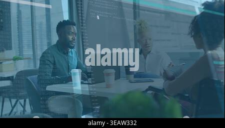 Discussing project, three colleagues leaning at office table with laptop, coffee, in office attire Stock Photo