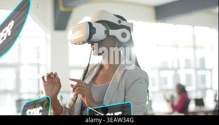 Gesturing woman wearing light gray blazer and VR headset, manipulating digital UI panels in office Stock Photo