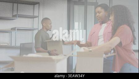 Packing three colleagues in casual shirts arranging cardboard boxes at office with bubblewrap Stock Photo