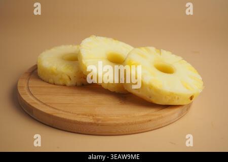 Sliced pineapple on a wooden board in bright light Stock Photo