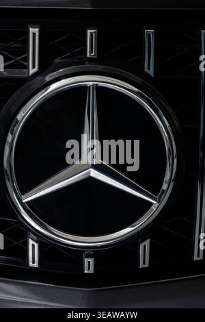 Mercedes-Benz Three-Pointed Star Hood Ornament on Luxury Car Front Grille Close-Up Stock Photo