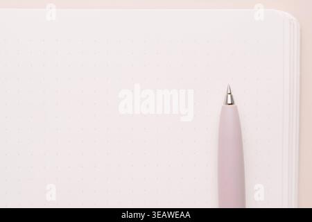 Pink pen on blank notebook page in minimal composition Stock Photo
