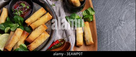 Crispy spring rolls with vegetables for appetizer on a dark background. Asian snack concept. Top view. Stock Photo