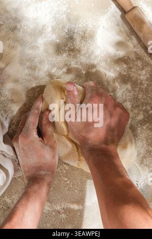 Artisan baker kneading sourdough dough, handson craft Stock Photo