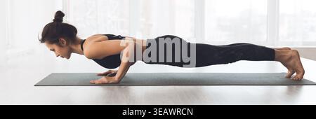 Practicing Advanced Yoga Pose Indoors in a Modern Studio With Natural Light Stock Photo