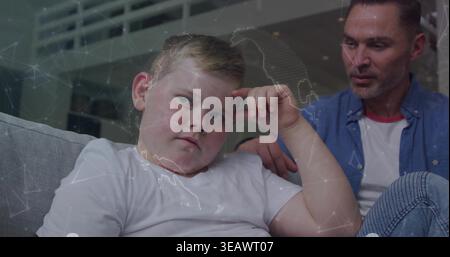 Sitting boy touching temple on gray couch at home, man in blue-shirt-and-jeans watching map-overlay Stock Photo