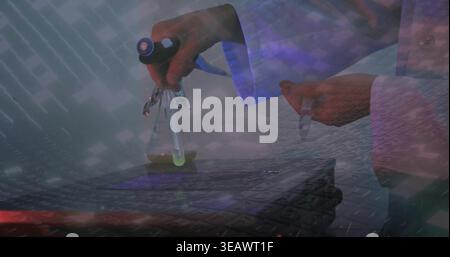 Pipetting lab tech in white lab coat manipulating Erlenmeyer flask, pipette and vial at keyboard Stock Photo