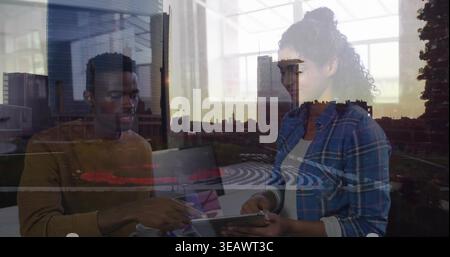 Viewing tablet plaid-shirt woman leaning as man pointing at screen at office window with laptop Stock Photo