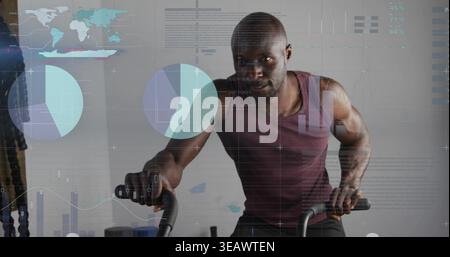 Pedaling muscular man wearing maroon top and shorts on spin bike in gym, displaying data overlays Stock Photo