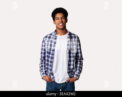 Young man looking at camera and holding hands in pockets Stock Photo