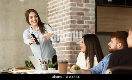 Engaging Presentation by a Young Woman in a Modern Office Setting During a Collaborative Meeting Stock Photo