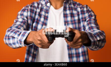 African-american guy playing video games online, holding joystick Stock Photo