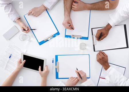 Medical Education. Doctors Writing On Clipboards At Seminar Stock Photo