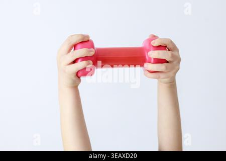 Children's Hands Holding Pink Dumbbell Horizontal on White Stock Photo