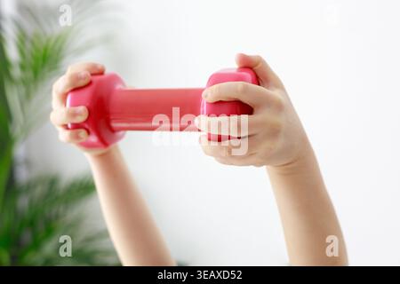Children's Hands Holding Pink Dumbbell Horizontal on White Stock Photo