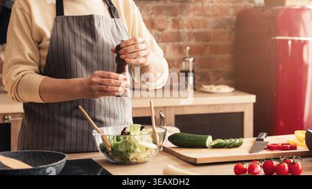 Creating a Fresh Salad in a Kitchen With Vegetables and Cooking Tools on a Counter Stock Photo