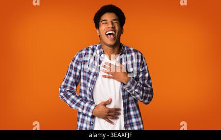 Can't stop laughing. Guy touching stomach, hearing jokes Stock Photo