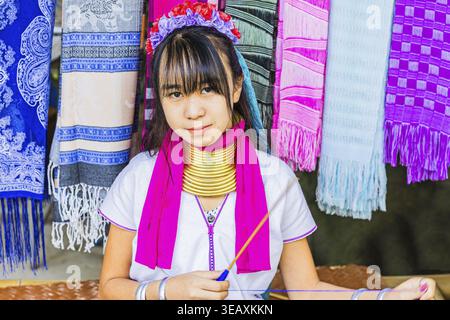 Young woman from the Karen minority group wearing brass rings around her neck, colorful traditional head covering and clothing, Karen Long Neck Villag Stock Photo