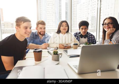 Skilled young programmers watching webinar on laptop computer Stock Photo