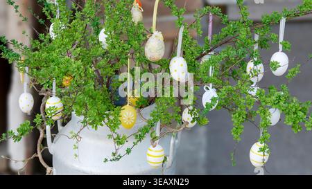 Rustic Easter Decoration Featuring Hanging Eggs and Green Branches Stock Photo