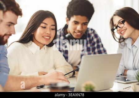 Group of Students Collaborating on a Laptop in a Cozy Study Space Stock Photo