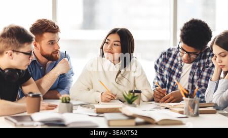 Students Collaborating in a Study Session at a Modern Workspace During the Afternoon Stock Photo