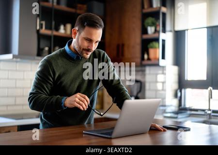 Success man typing on laptop, communicating online distantly working or studying on computer at home Stock Photo