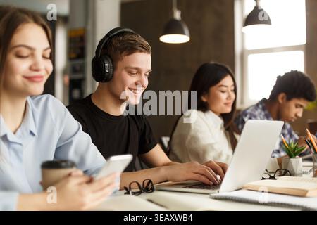 Young People Engaged in Focused Work at a Modern Workspace During Afternoon Hours Stock Photo