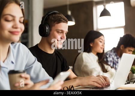 Smart smiling guy studying in school library Stock Photo