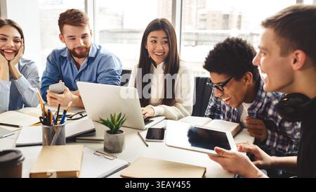 Group of Young Adults Engaged in Collaborative Study at a Modern Workspace Stock Photo