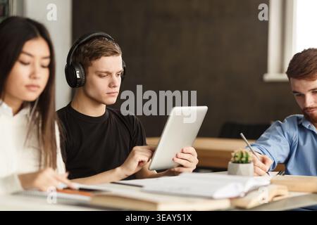 College student surfing internet on tablet in library Stock Photo