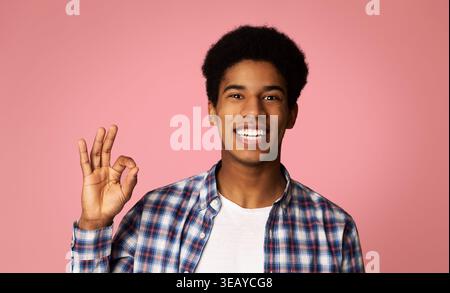 Happy Afro Guy Gesturing OK Sign and Smiling Stock Photo