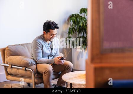 Casual Businessman using a smartphone in office Stock Photo