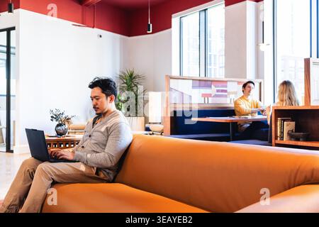 Young Asian Man Working in a collaborative Environment Stock Photo