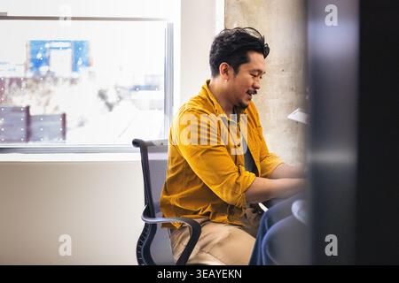 Young asian professional man working at a desk in the office Stock Photo