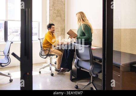 Young coworkers in discussion in modern office space Stock Photo