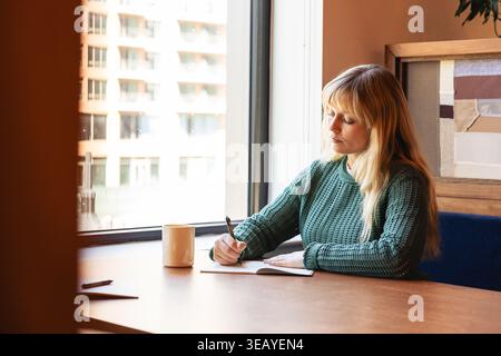 Caucasian woman taking notes at the office Stock Photo